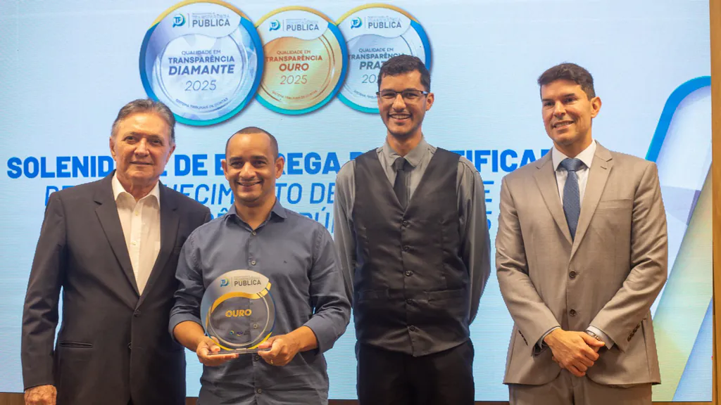 Pelézinho segura o troféu do Selo Ouro de Transparência Pública 2025 ao lado do controlador interno da Câmara, Willian Santos, e de outros dois participantes da solenidade do TCE-MT