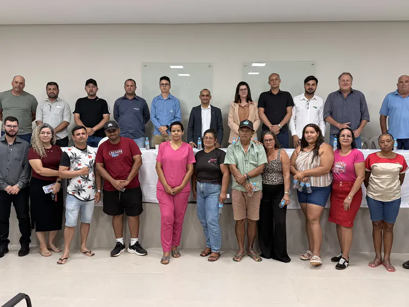Vereadores, representantes da concessionária e moradores posam juntos em frente à mesa no encerramento da audiência pública sobre a água no Jardim Rio Claro