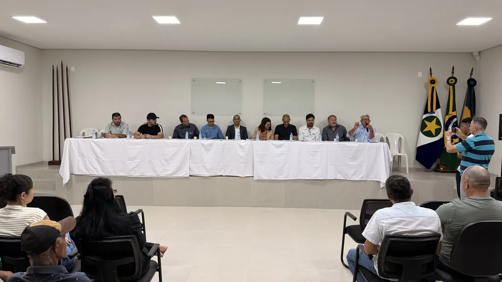 Vista do salão da 18ª CIPM durante a audiência pública, com a mesa de autoridades ao fundo e moradores sentados na plateia
