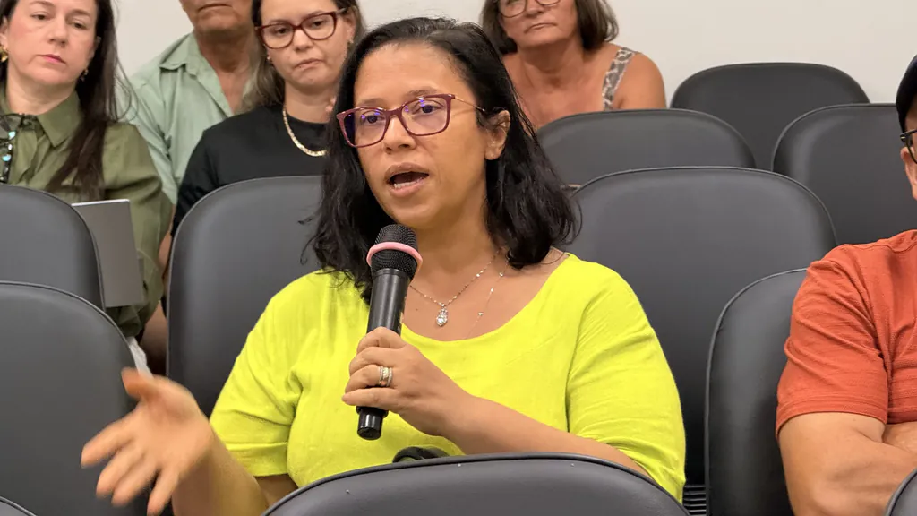 Moradora fala ao microfone na plateia durante a audiência pública sobre o abastecimento de água
